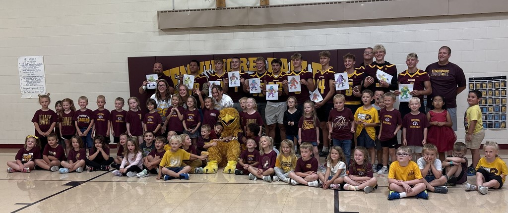 football team visits with kindergarten in the gym on homecoming day