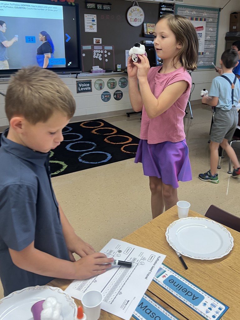a student jumps to see if their seed will stay on their "flufadoo" animal