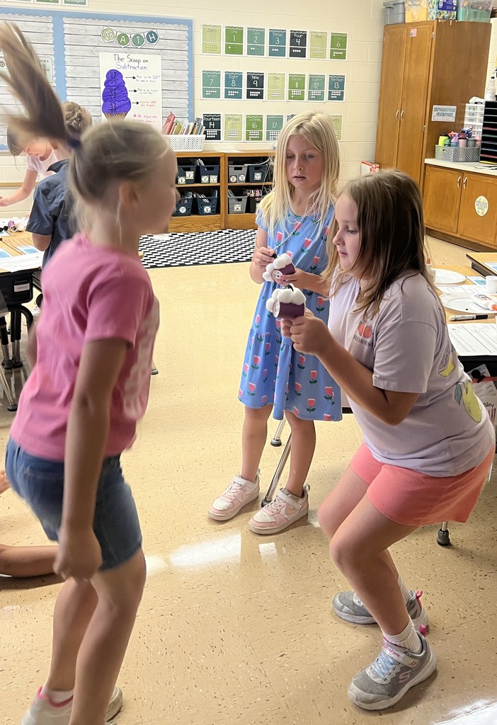 a student jumps to see if their seed will stay on their "flufadoo" animal
