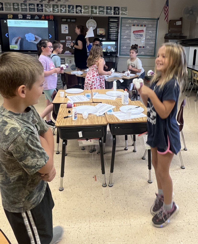 a student jumps to see if their seed will stay on their "flufadoo" animal