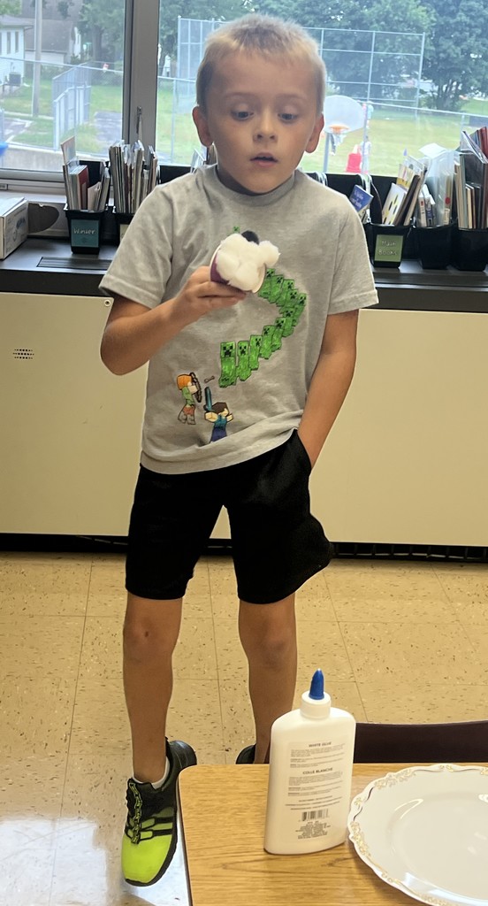 a student jumps to see if their seed will stay on their "flufadoo" animal