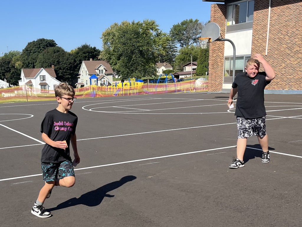 students run on playground during the predator/prey game
