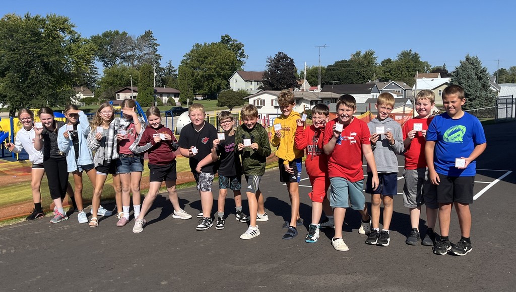 students show off the cards they collected in the predator play game outside