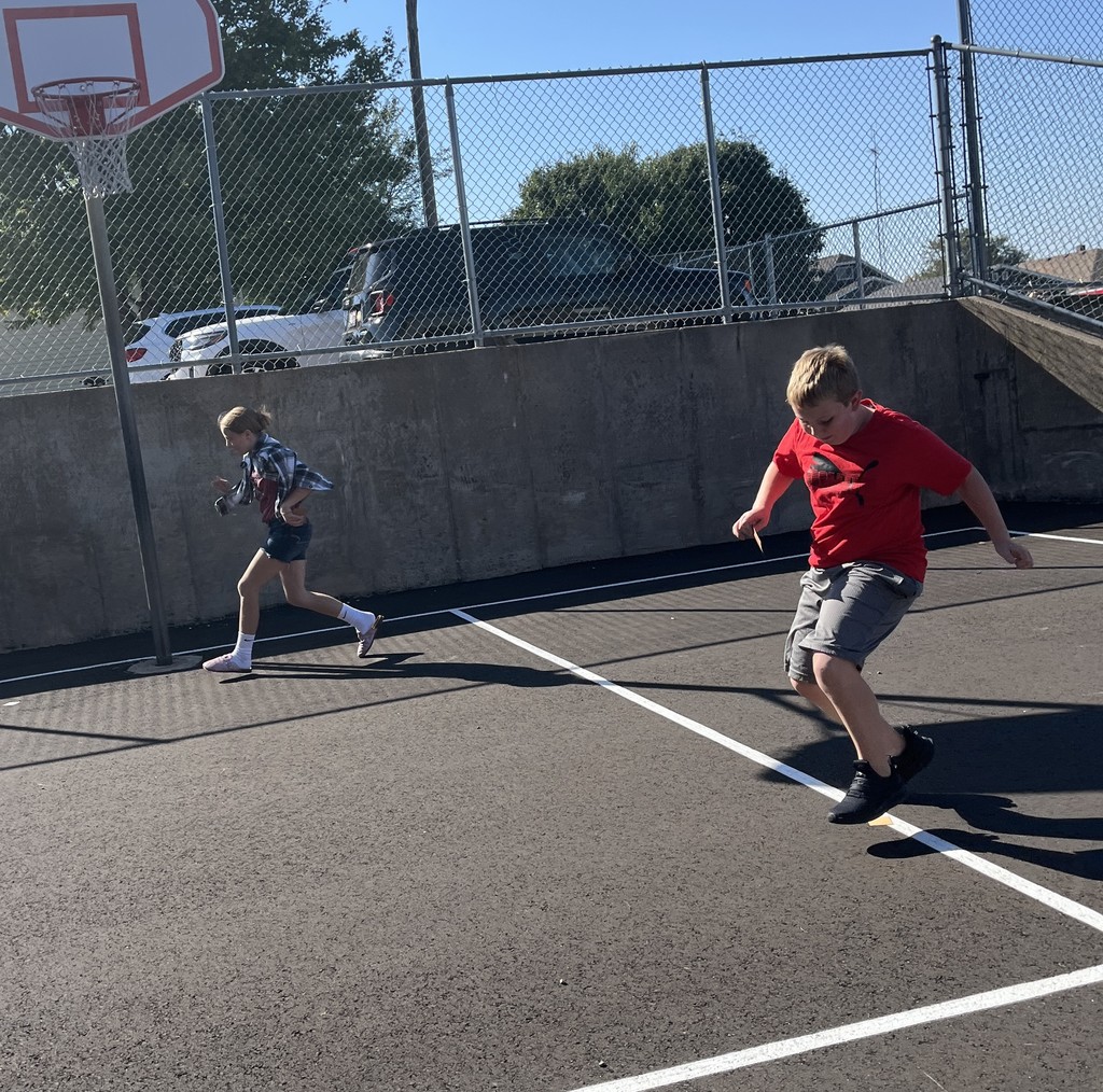 students run on playground during the predator/prey game
