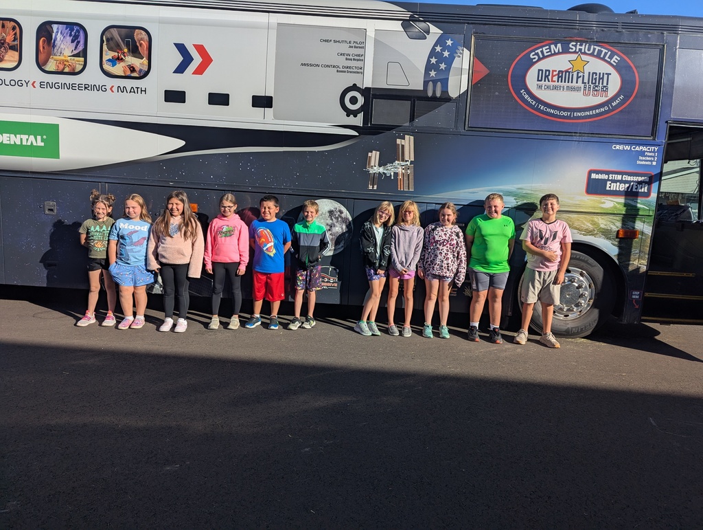 students lined up for a picture outside the stem shuttle bus