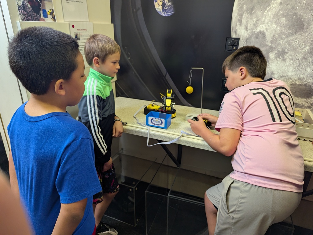 students use a robotic arm to move things on the STEM shuttle bus