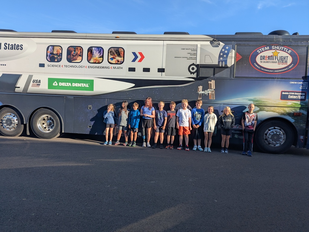 students lined up for a picture outside the stem shuttle bus