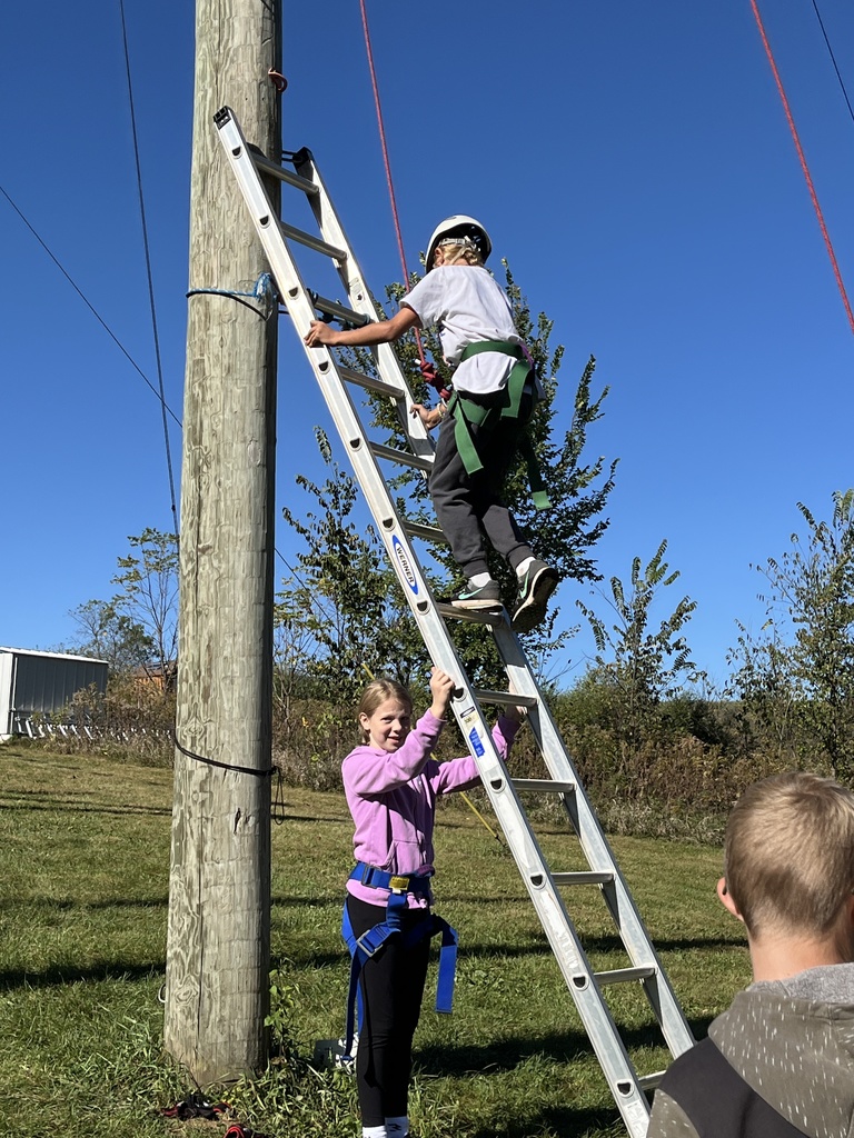 one student holds the ladder as the other student climbs it at bethel horizons