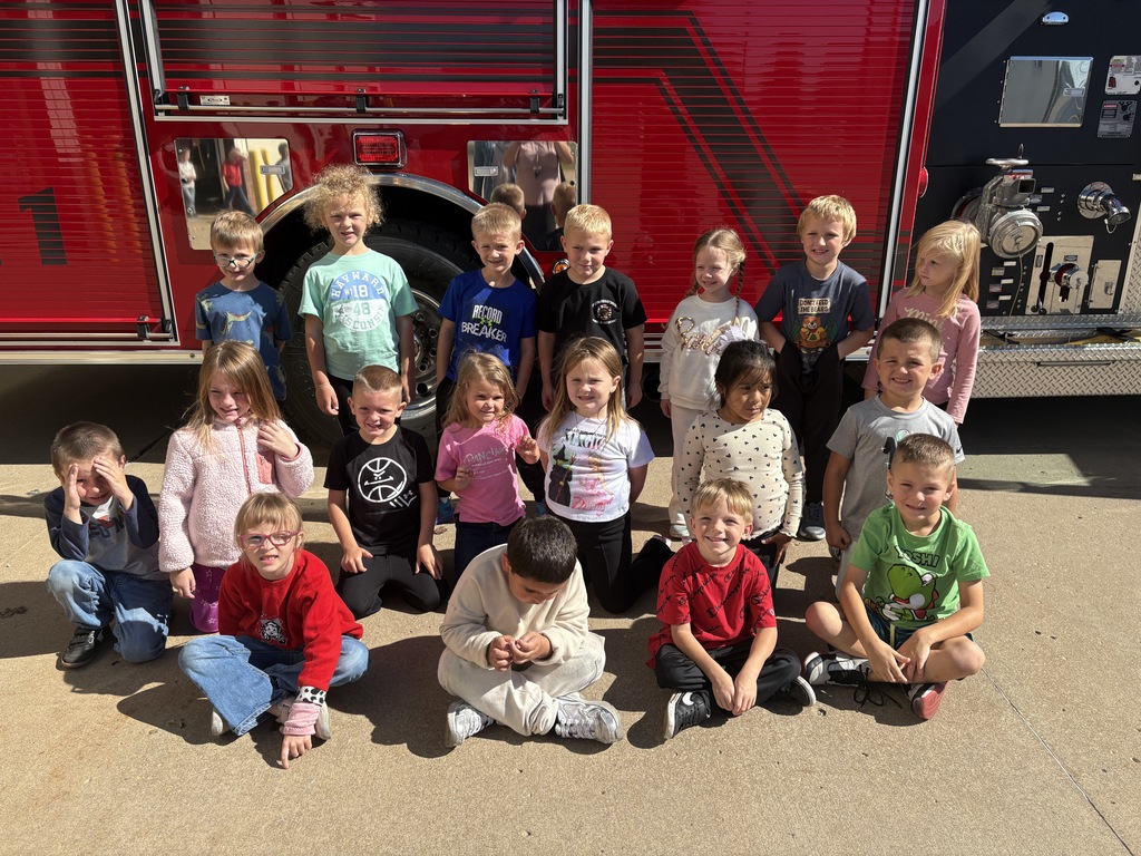 students pose for a picture in front of a fire truck at fennimore fire station.