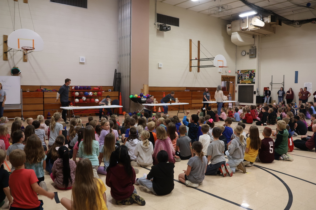 teachers complete in jenga challenge as students sit and cheer them on