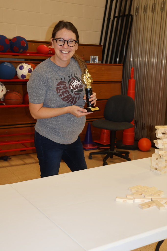 Mrs. Wienkes wins the Jenga teacher challenge and shows off her trophy