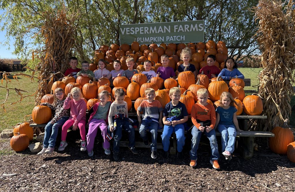 students pose for a picture with pumpkins at VEsperman farms