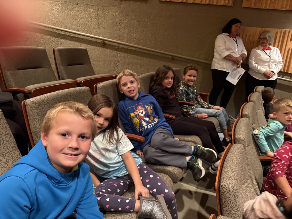 students sit in their seats at the Heritage Center waiting for the play to start