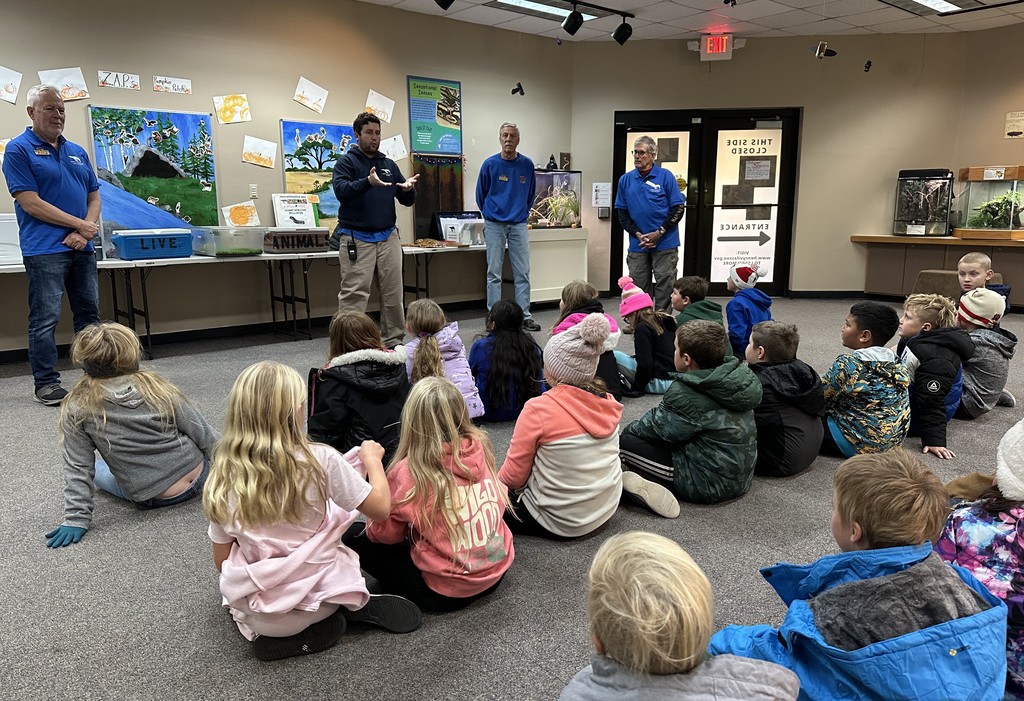 students listen and learn from the zoo workers at the zoo