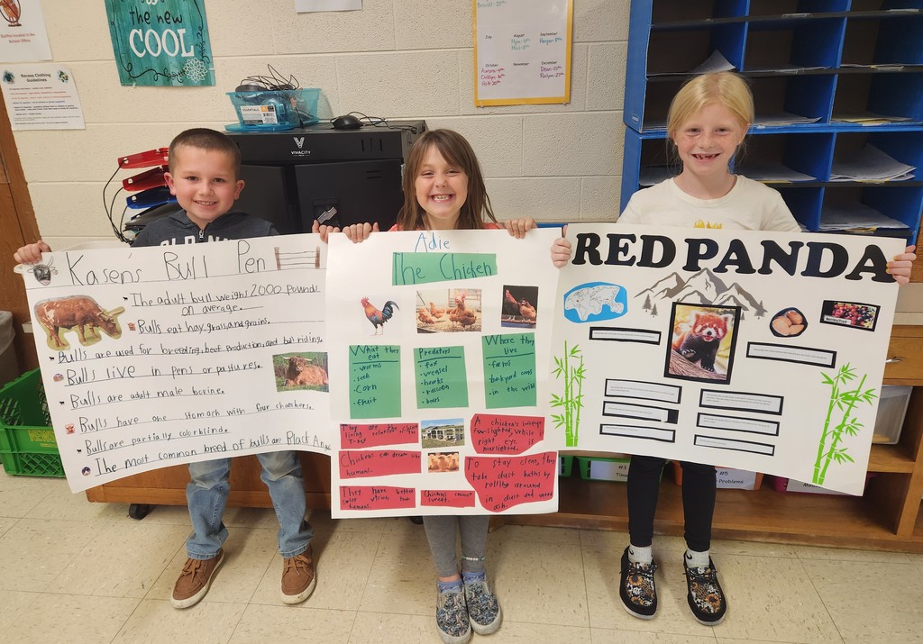 students show off their animal posters