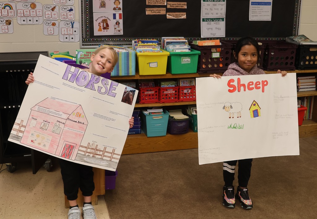 students show off their animal posters