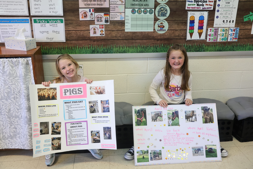 students show off their animal posters