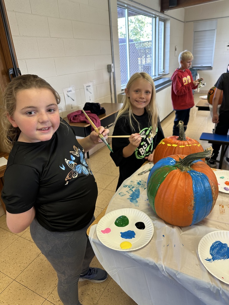 students paint pumpkins