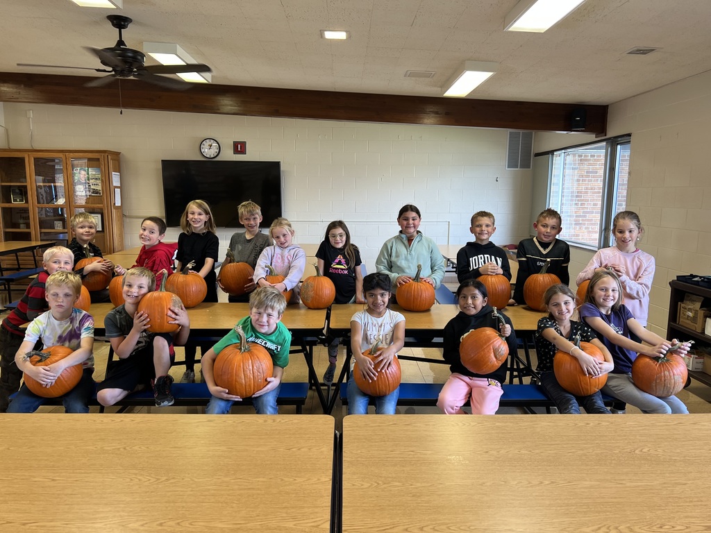 students hold on to their big pumpkin