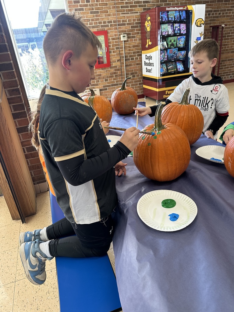 students paint pumpkins