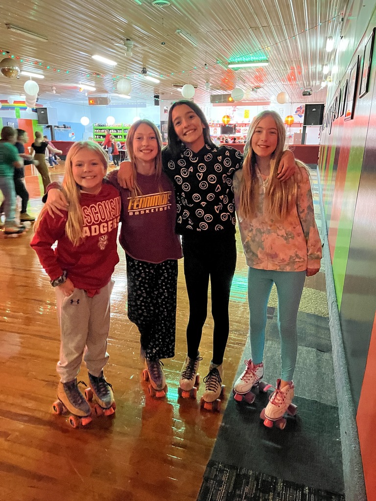students with skates on smile for a picture