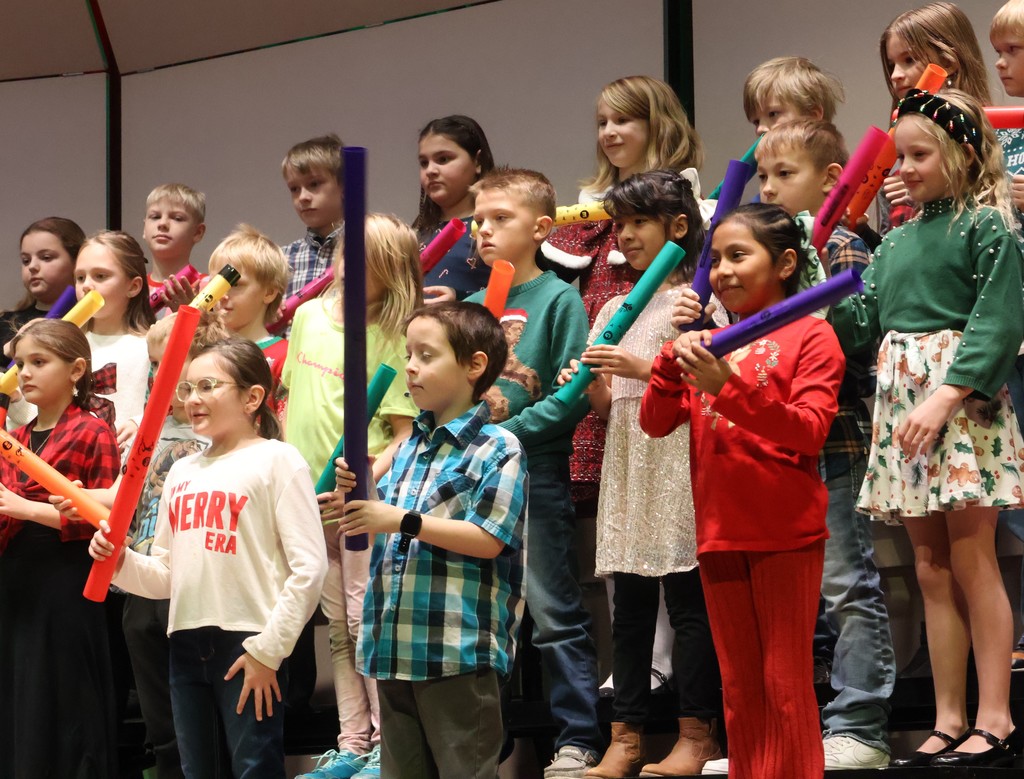 3rd grade elementary students sing at their concert with boomwhackers