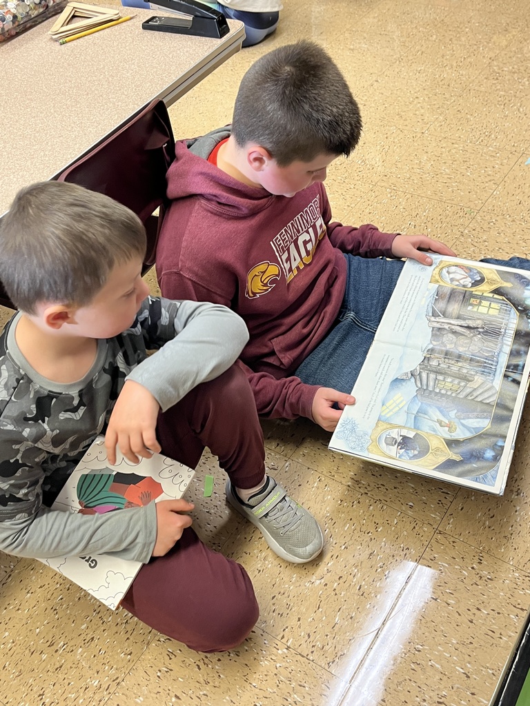 students sit on the floor and read a book together