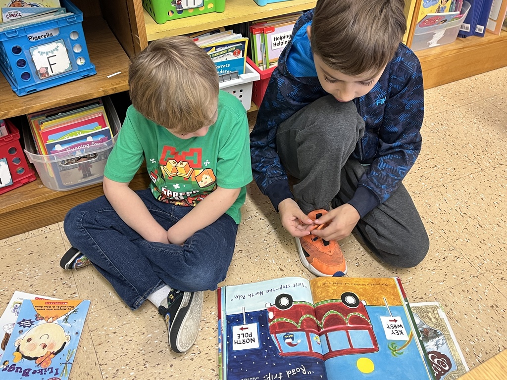 students sit on the floor and read a book together
