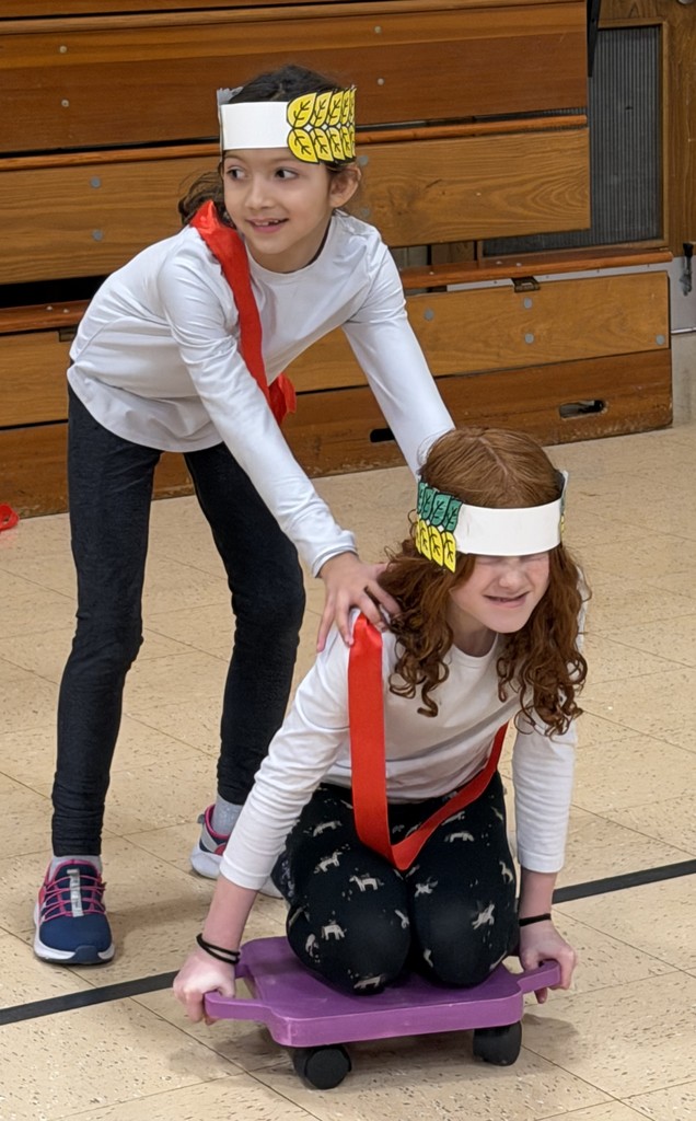 students doing chariot races in the gym