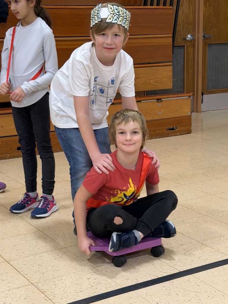 students doing chariot races in the gym