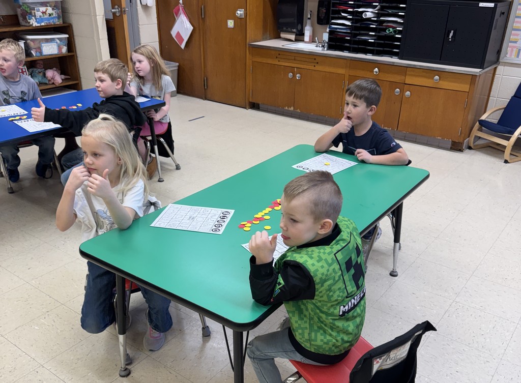 students sit at a table with their bingo cards