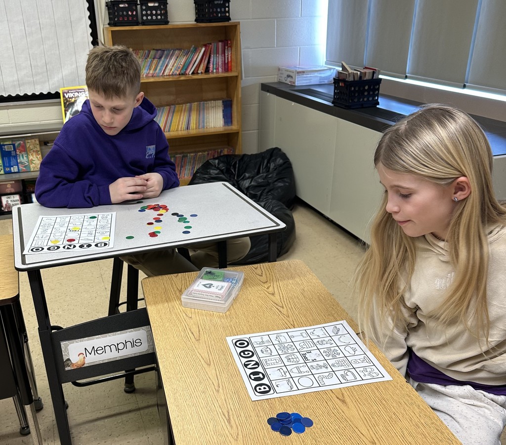 students sit at their desks with their bingo cards