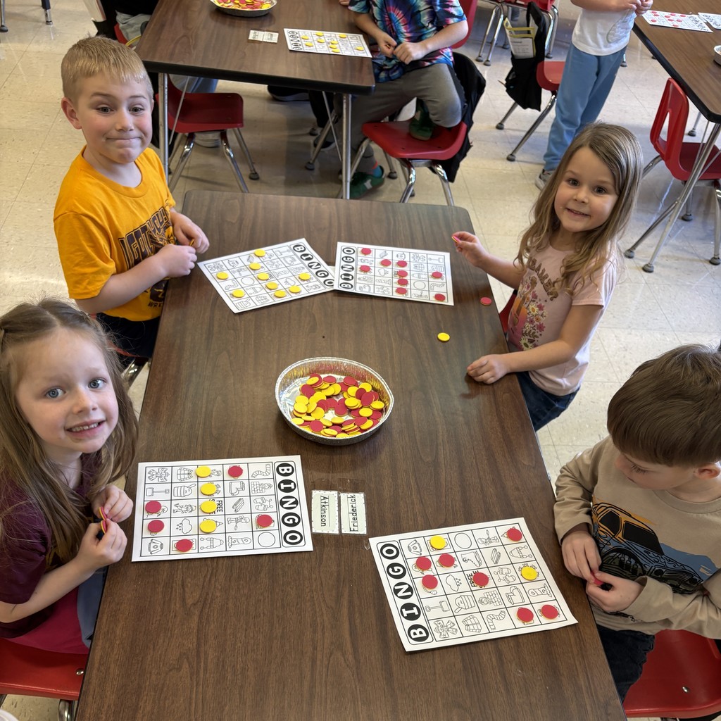 students sit at a table with their bingo cards