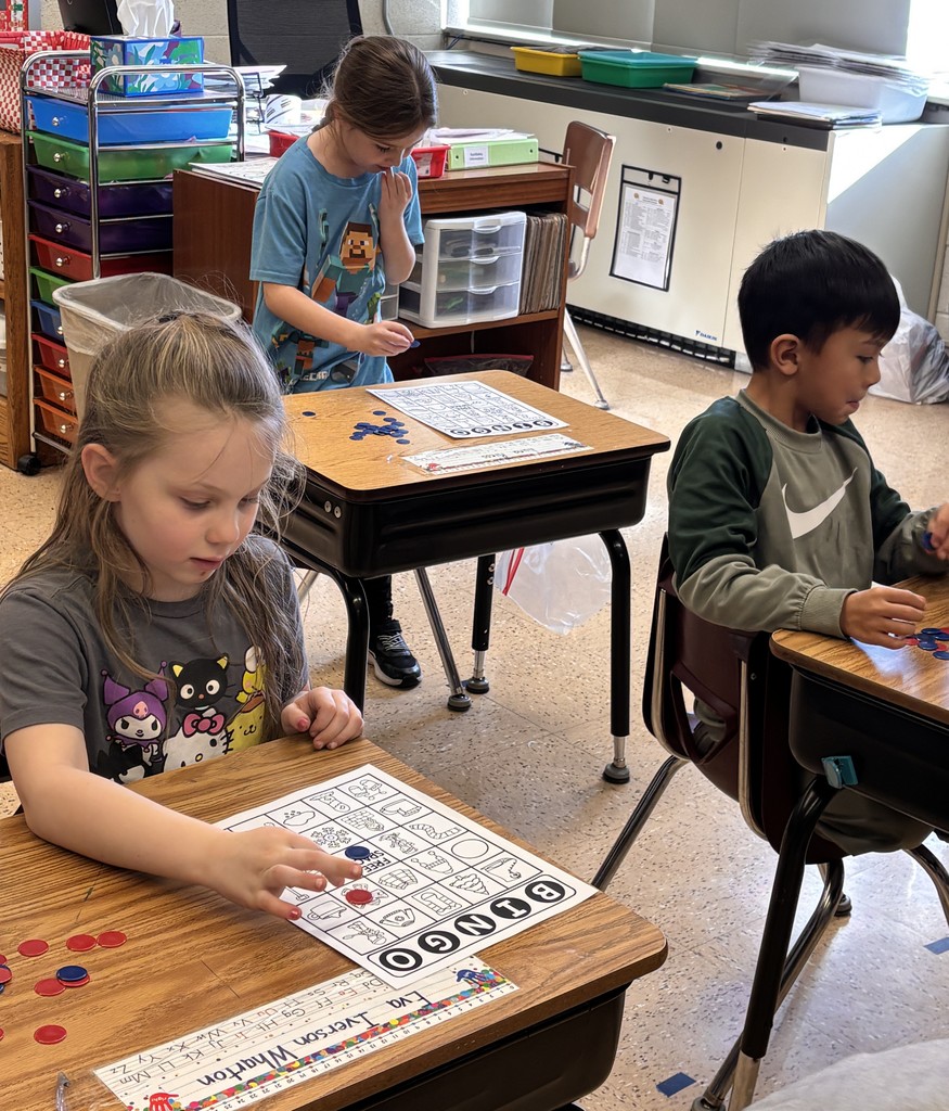 students sit at a table with their bingo cards