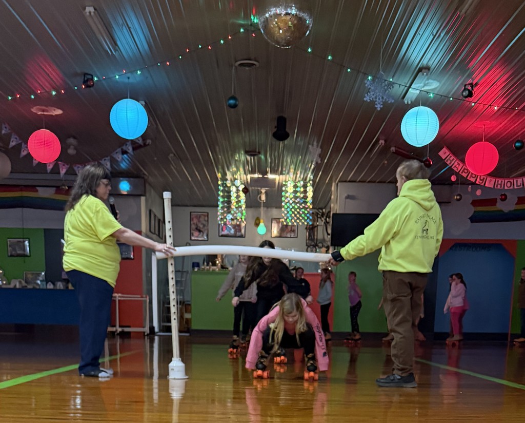 students do the limbo on skates at the rink
