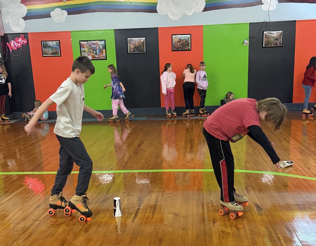 student skate at the rink around a paper cup