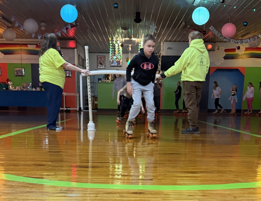 students do the limbo on skates at the rink