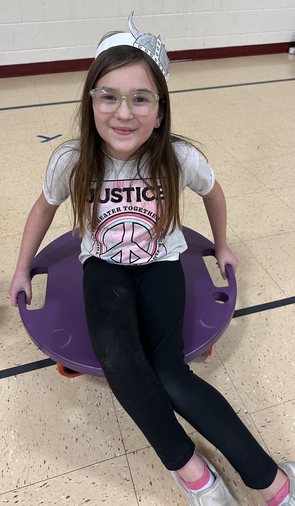 A student sits on their board scooter and gets ready to race