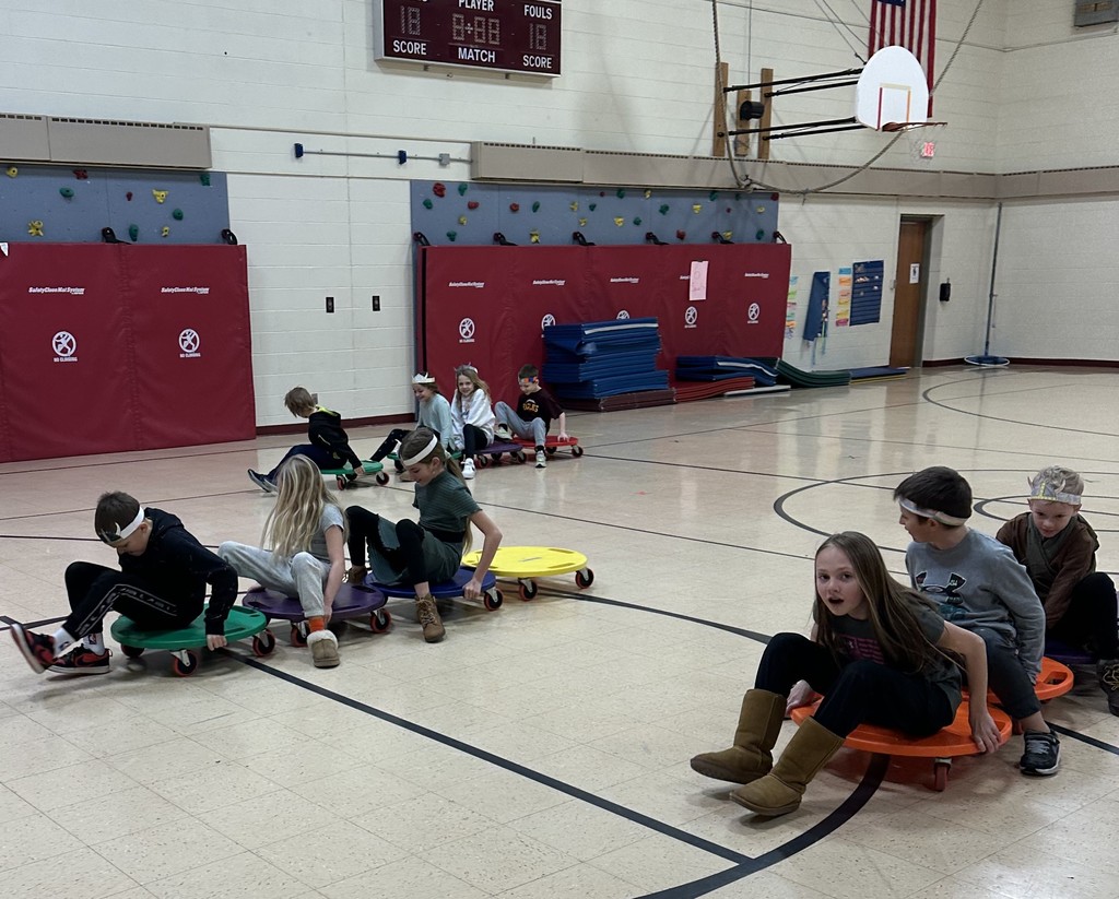 students race in teams on their board scooters in the gym