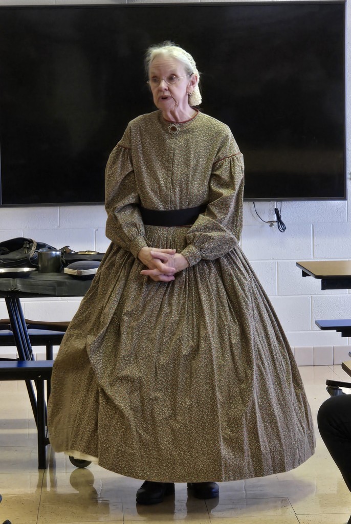 The civil war presenters   dressed in civil war era garb speak with the students