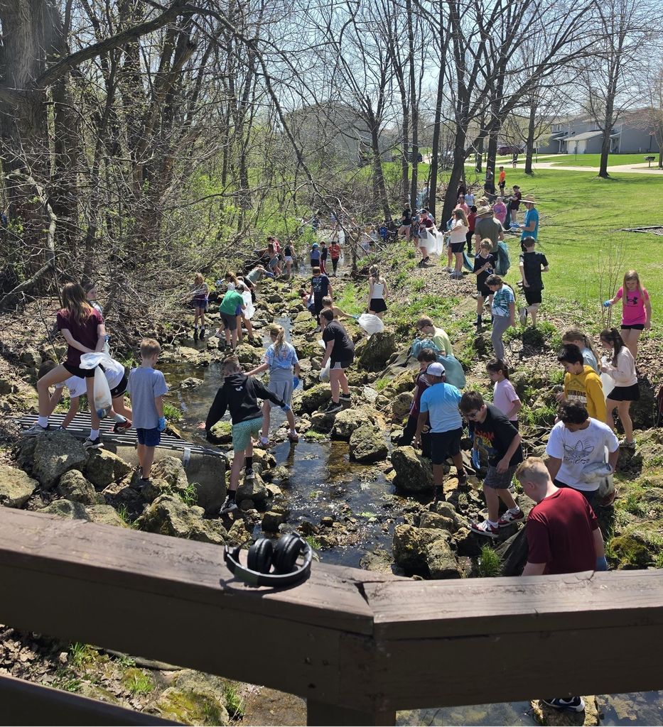 students pick up trash in creek bed on earth day