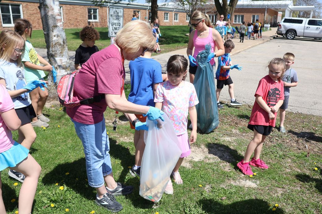 students put trash in the teacher's garbage bag