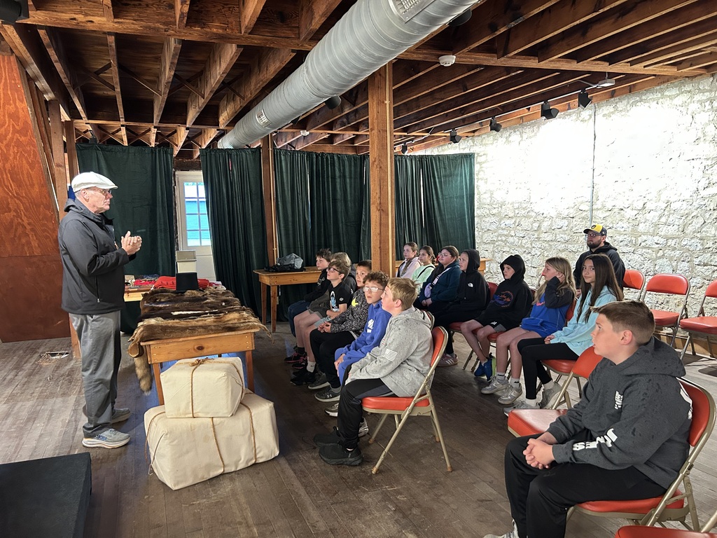 students listen to a speaker on their field trip