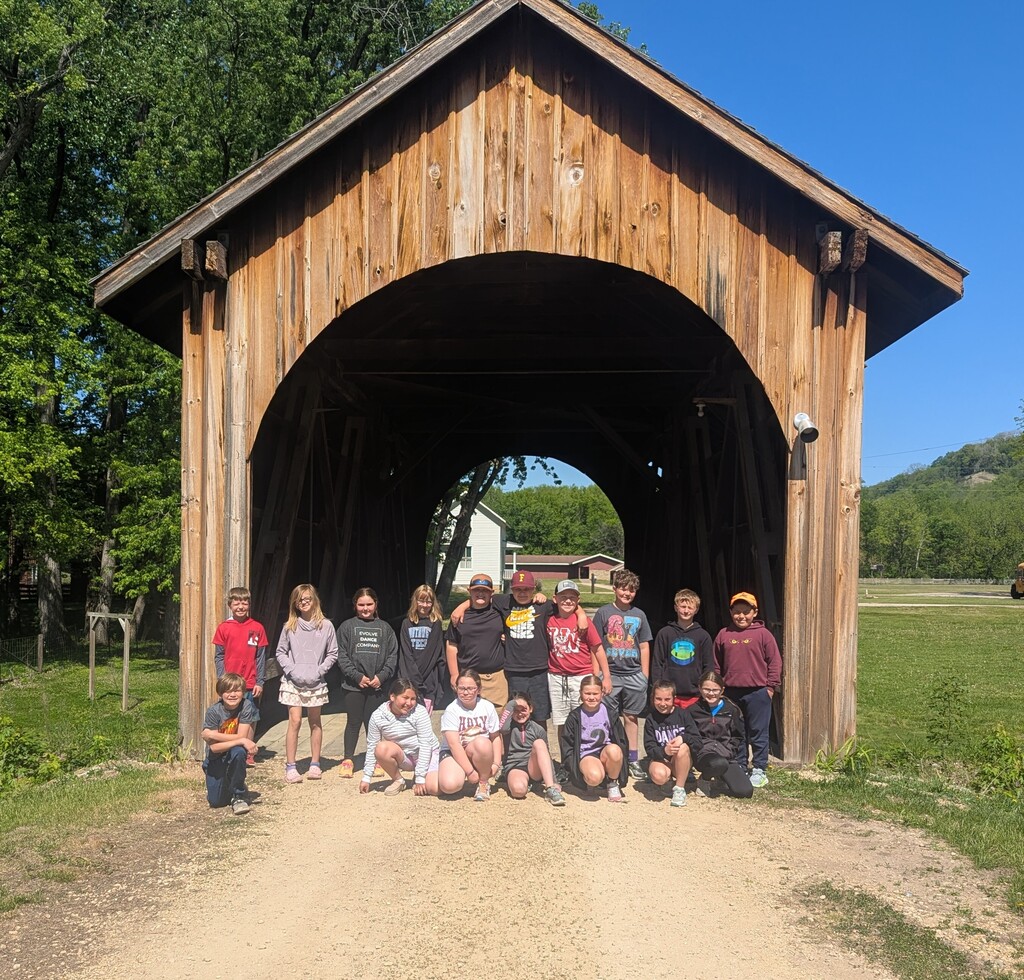 students pose for a picture at a covered bridge at Stonefield