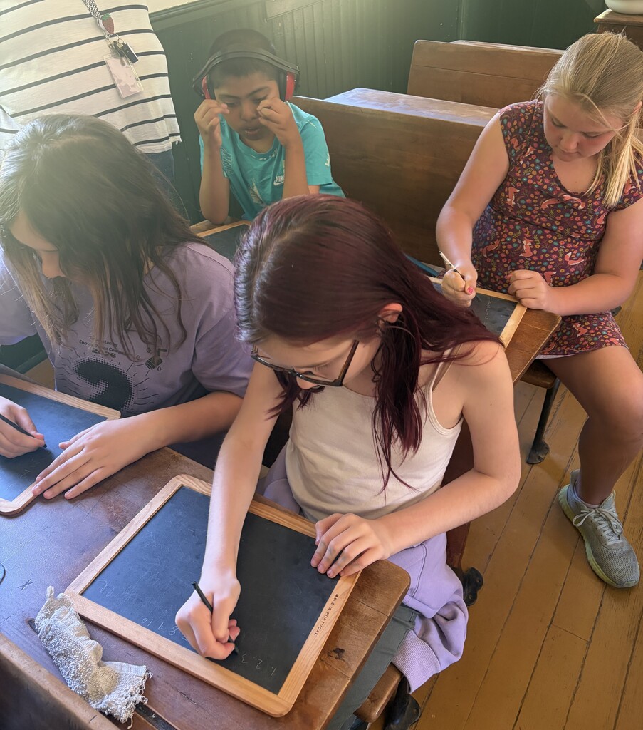 students take a spelling test in the one room schoolhouse at Stonefield