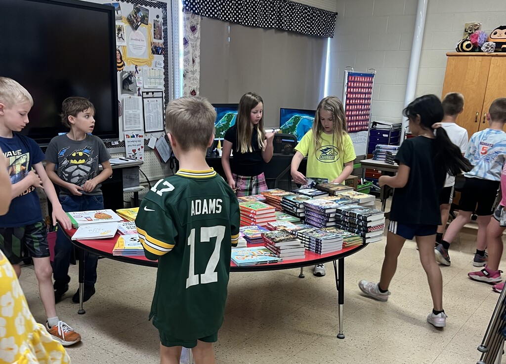 students look for the book they want from a table full of books