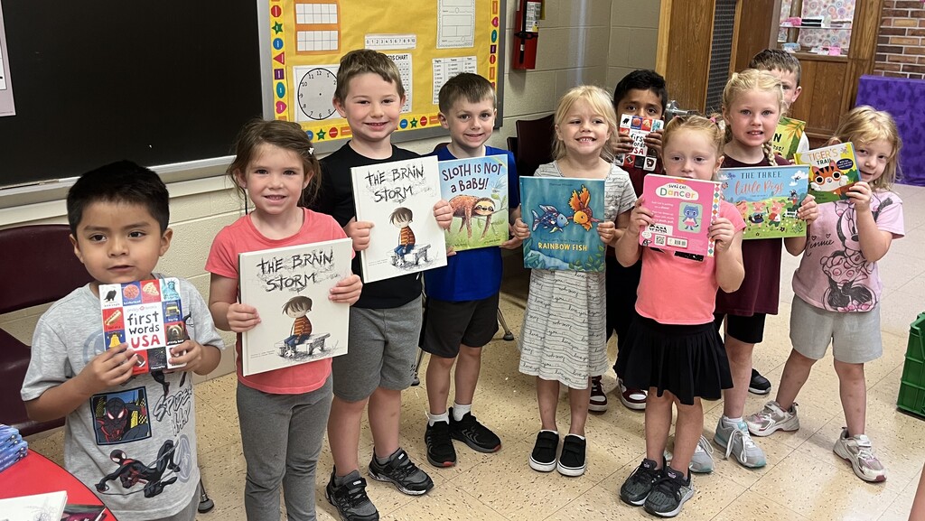 student show off their new books for a picture
