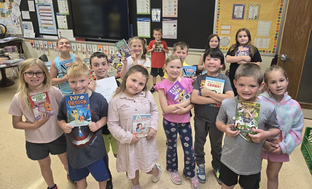 student show off their new books for a picture