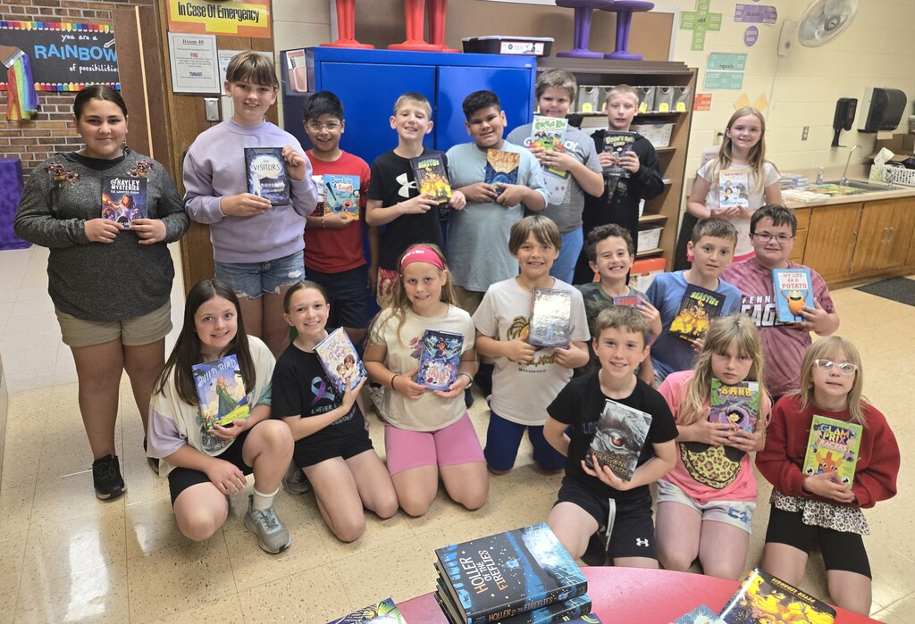 student show off their new books for a picture