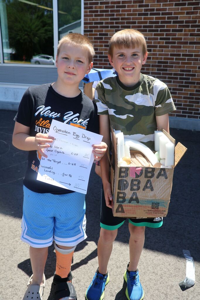 the winners hodl up their contraption and their score sheet